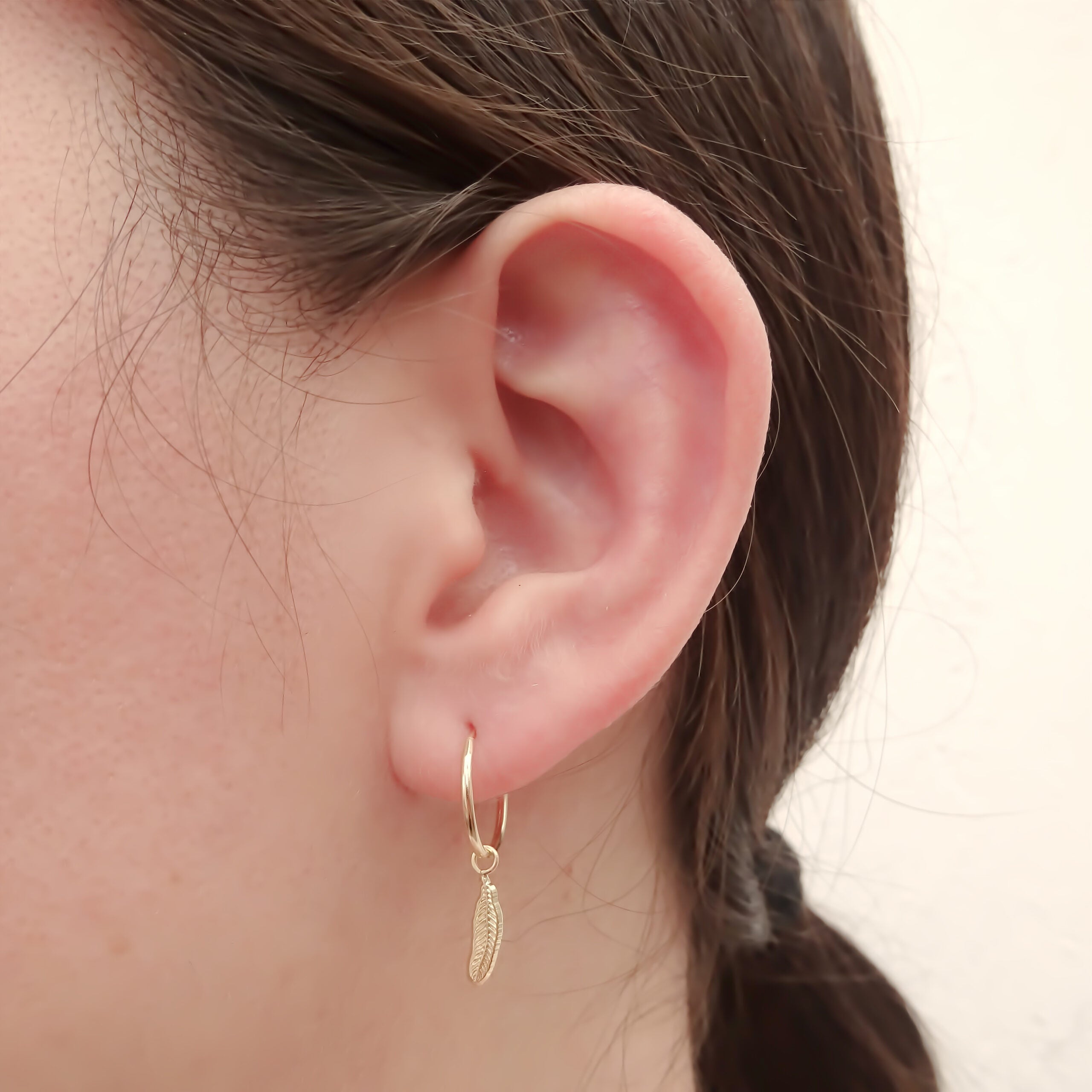 Dije con arracada Pluma Oro 10k.