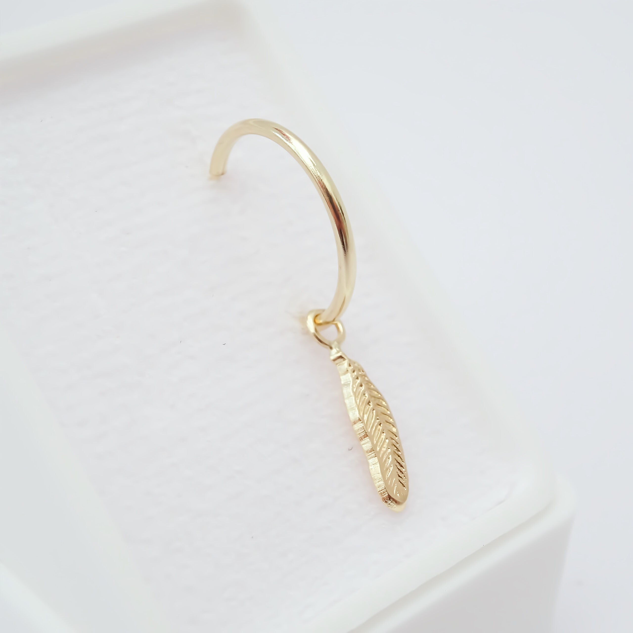 Dije con arracada Pluma Oro 10k.