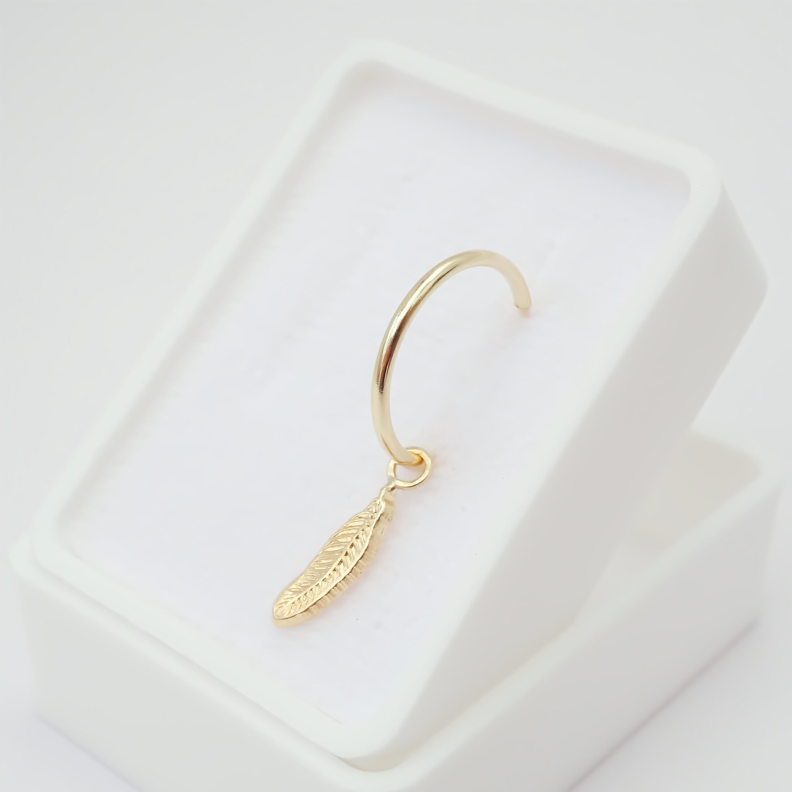 Dije con arracada Pluma Oro 10k.